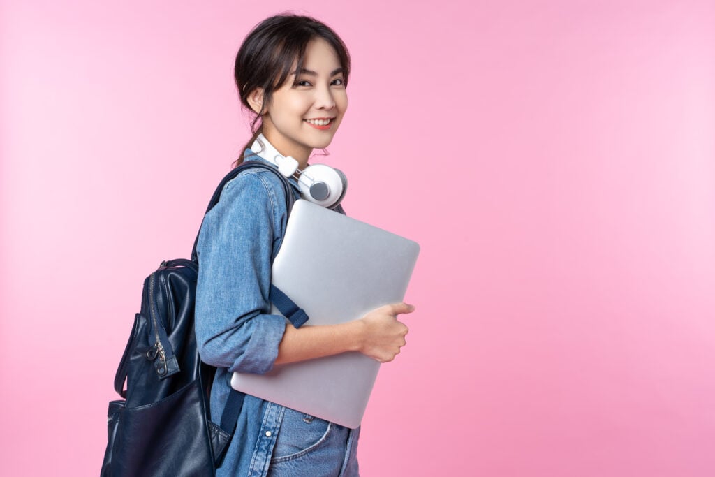 portrait,of,smiling,young,asian,college,student,with,laptop,and