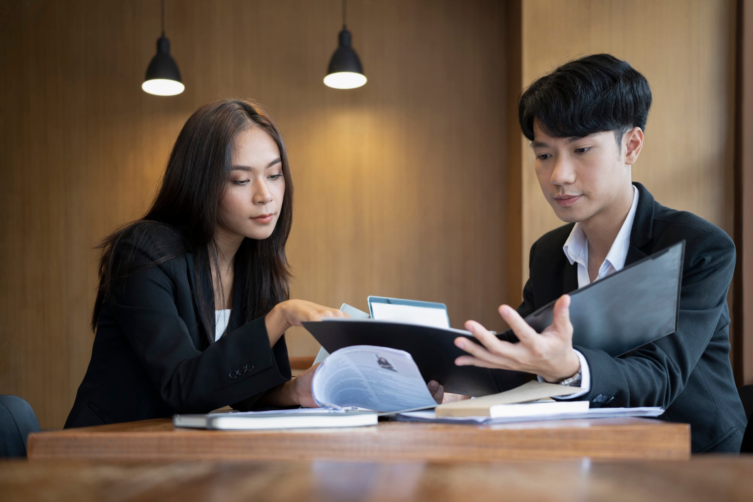 two successful business people analyzing financial reports together office scaled