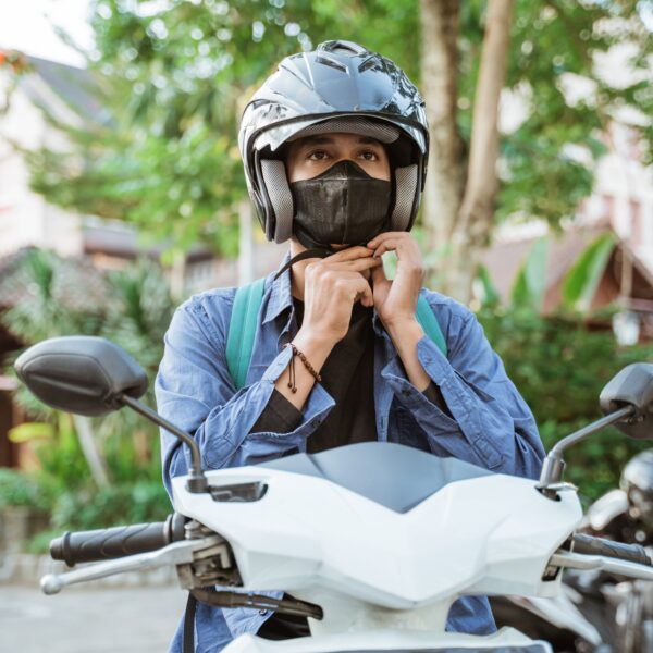 man,getting,ready,to,wear,helmet,and,mask,on,motorbike